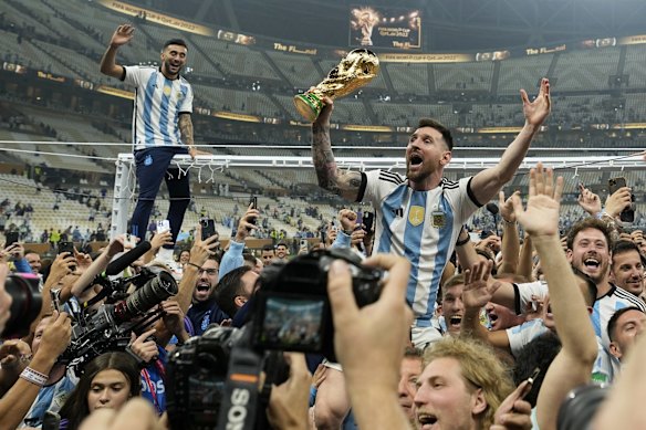 Argentina's Lionel Messi celebrates with the World Cup trophy in front of fans after winning the final soccer match between Argentina and France at Lusail Stadium in Lusail, Qatar. December 18, 2022.