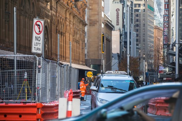 Cars and pedestrians navigate the construction of the light rail at the intersection of George Street and Park Street, Sydney.