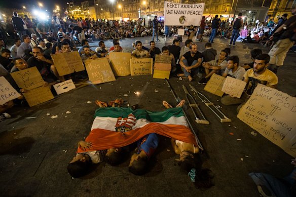 Migrant children sleep under a Hungarian flag in front of Keleti station, in central Budapest. 