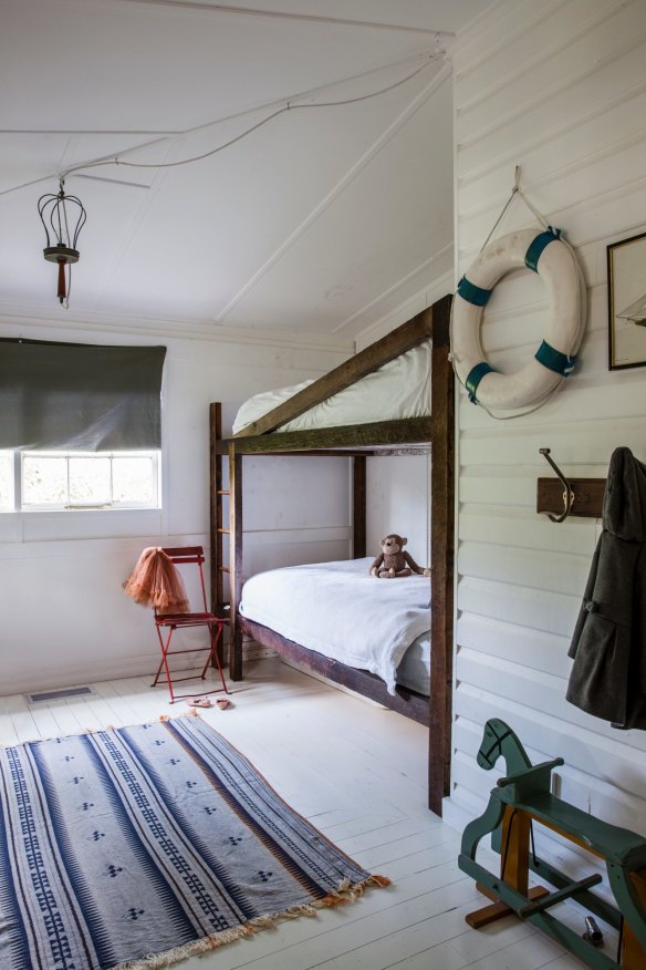 ”We wanted our kids to share a bedroom,” says Tim. “The bunks are made of the hardwood from the walls of the original house.”