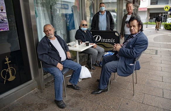 Assyrian singer Gaggi Atoraya, right, reconnects with friends over a coffee, in Fairfield, after the Covid-19 stay at home lockdown orders are lifted. 