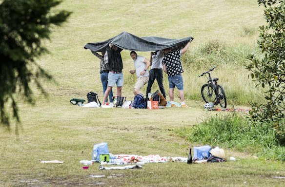 Picnics are packed up as the rain begins to fall at Centennial Park, as some restrictions ease.