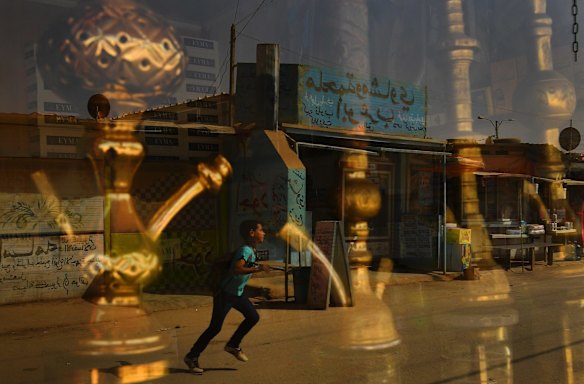 A boy runs across Shams Elysee in Zaatari Camp in Jordan.