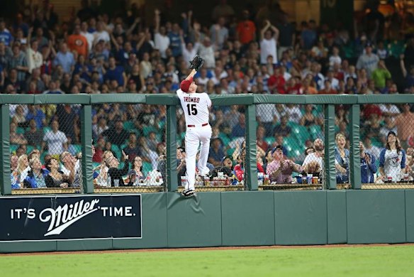 Diamond backs left fielder Mark Trumbo tries to catch a hit on the fence.