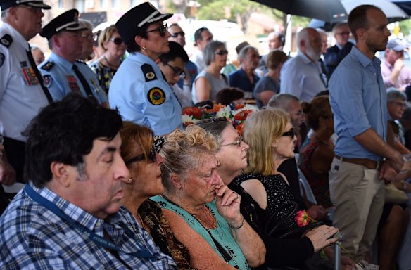 People pray during a ceremony at the monument in Granville.
