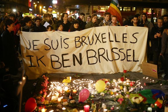 People hold up a banner as a mark of solidarity at the Place de la Bourse following the attacks in Brussels.