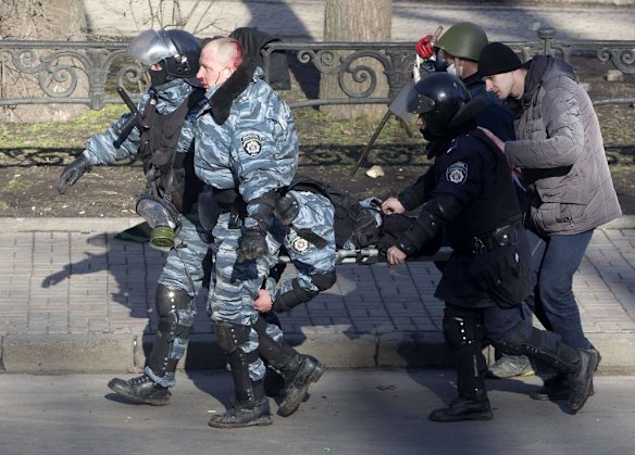 Riot police officers carry their colleague who was injured during clashes with anti-government protesters in Kiev, February 18, 2014. Ukrainian riot police advanced on the heart of 12-week-old protests against President Viktor Yanukovich on Tuesday and security forces set a deadline to end disturbances after at least five protesters were reported killed in a day of clashes.