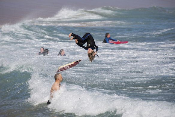 People at Sorrento Ocean Beach enjoying the surf.