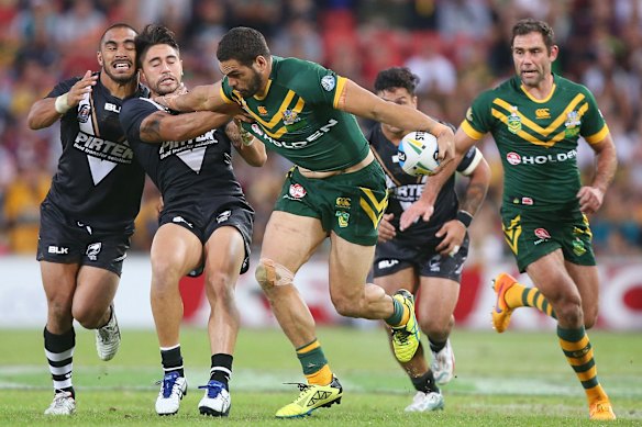 Greg Inglis of Australia makes a break and hands off the Kiwis' Shaun Johnson. 