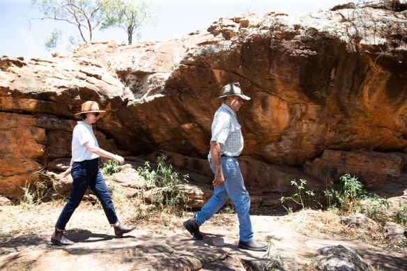 Uncle Peter Harris leads Premier Gladys Berejiklian past rock shelters containing ancient art at Mount Grenfell. 
