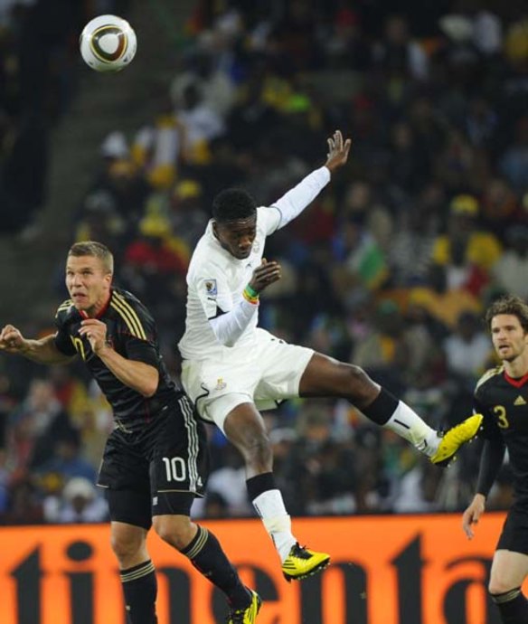 Ghana's striker Asamoah Gyan (R) fights for the ball with  Germany's striker Lukas Podolski.