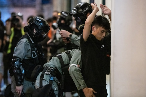 A demonstrator is searched by police.