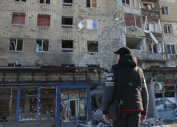 A man looks at a damaged by shelling building in Kharkiv, Ukraine.