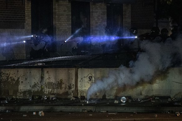 Minneapolis police look out from a building at the 3rd Precinct.
