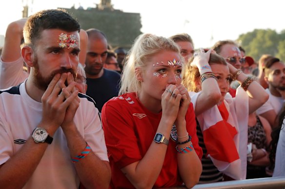 England soccer fans react as they watch a live broadcast on a big screen of the semifinal match between Croatia and England at the 2018 soccer World Cup, in Hyde Park, London.