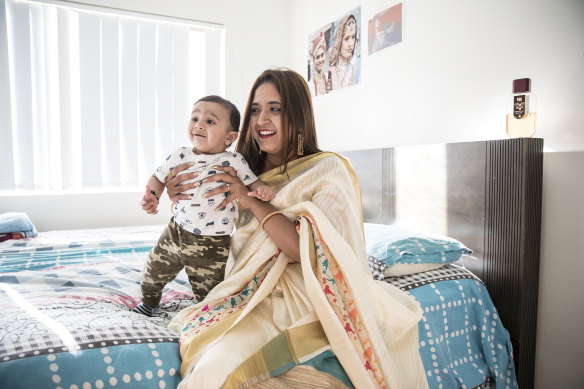 Himali sits on her bed with her 10-month-old nephew Prayaan.