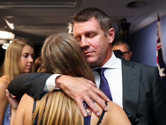 Premier Mike Baird hugs his daughter after a press conference announcing his resignation in Sydney.
