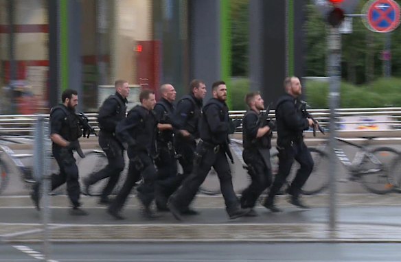 In this grab taken from video, police run in the area of the Olympia Einkaufszentrum mall.