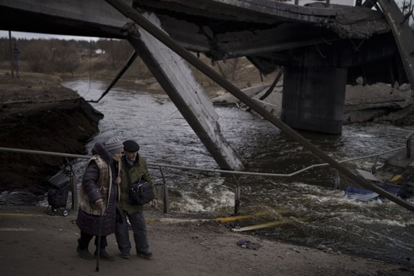 Elderly residents cross a destroyed bridge in Irpin on the outskirts of Kyiv, Ukraine.