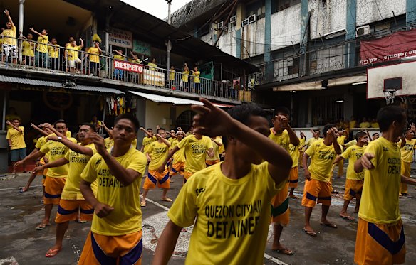 Inmates singing and dancing during an exercise routine inside Quezon City Jail, Manila, Philippines.