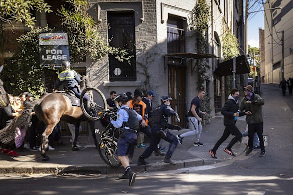 People break through a line of Mounted Police during an anti-lockdown protest in Chippendale, Sydney.