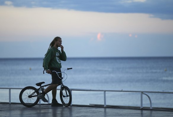 A boy gestures as he looks near the scene of an attack after a truck drove on to the sidewalk and plowed through a crowd of revelers who'd gathered to watch the fireworks in the French resort city of Nice, southern France.