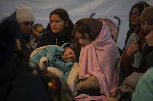 Refugees, mostly women with children, rest inside a tent after arriving at the border crossing, in Medyka, Poland.