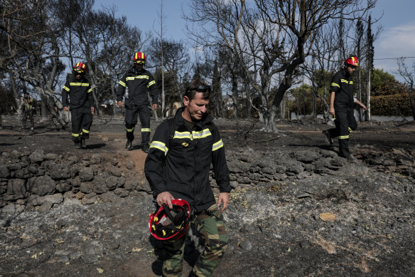 Members of a rescue team search for missing persons following the fire at Mati.