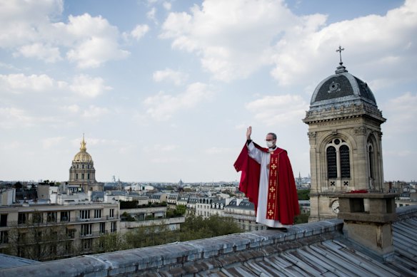 Father Bruno Lefevre Pontalis stands on the rooftop of Saint Francois Xavier church to bless the city of Paris during the national lockdown for Covid-19 at Easter, in Paris, France.