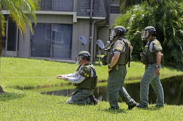 Bomb disposal officers check for bombs at an apartment complex of the suspected shooter.