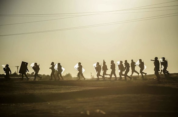 Turkish police walk during clashes with Kurdish protesters near the Mursitpinar border crossing on the Turkish-Syrian border in the southeastern town of Suruc, Sanliurfa province, on October 4, 2014. Photo by AFP