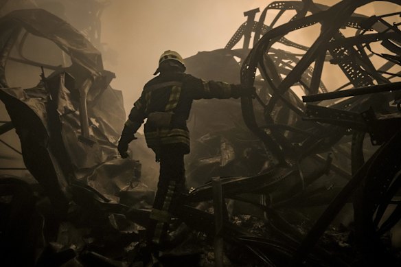 A Ukrainian firefighter walks inside a large food products storage facility destroyed by an airstrike on the outskirts of Kyiv.
