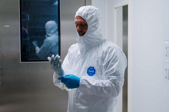 The lab’s head, Associate Professor Stuart Turville dresses up in extensive PPE gear within the second chamber of the PC3 lab.