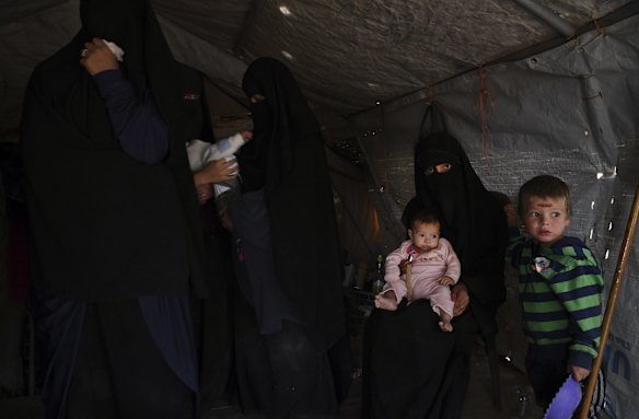 Shayma Assaad (2nd from right) with her daughter Mariam on her knee and son (right) amongst  other Australian women and children in Al-Hawl camp in North East Syria. 