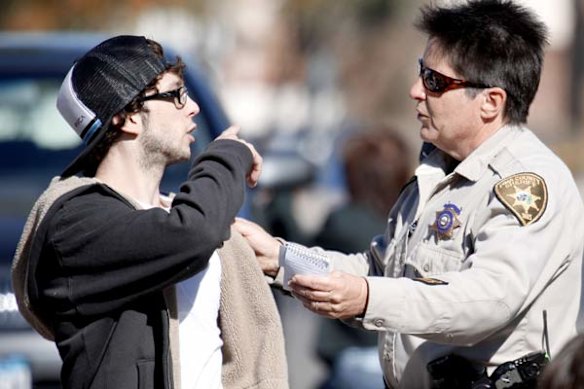 Police speak to a man at the scene of the Tucson shooting.