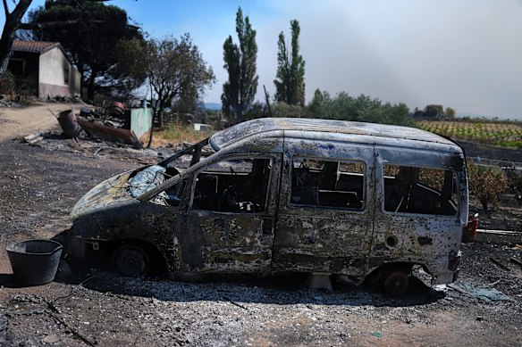 A burnt vehicle sits outside a charred house in Navas del Rey, west of Madrid.