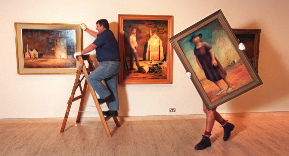 Gallery staff hang paintings by Russell Drysdale (L-R The Cricketers, Picture of Donald Friend and Woman in a Landscape) for a major retrospective at the Art Gallery of NSW on March 25, 1998.