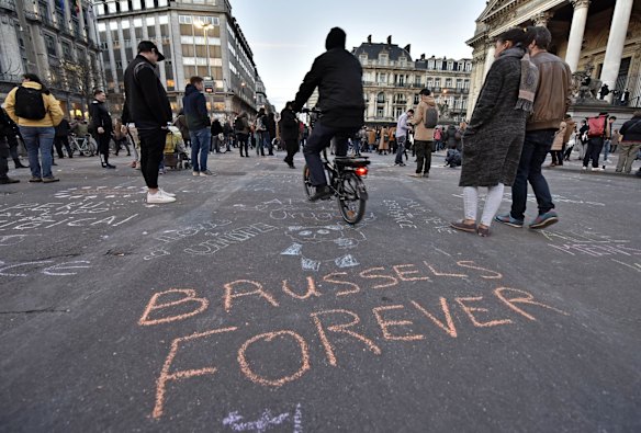 A writing on the asphalt reads "Brussels forever" at the place de la Bourse in the center of Brussels, where people write hundreds of messages on the ground to remember the victims of todays attack.