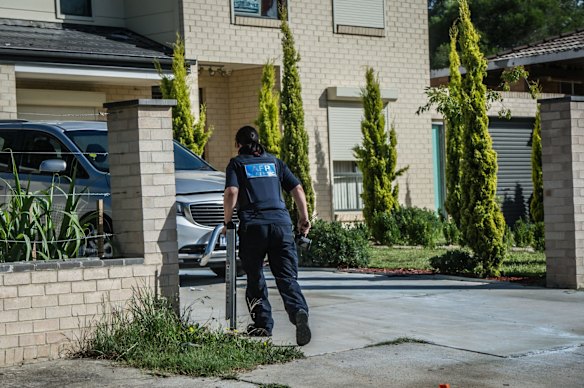 Police officers and forensic staff attend the scene of an overnight shooting and arson attack in Harrington circuit, Kambah. Numerous bullets have hit the home and three vehicles have been set alight. 