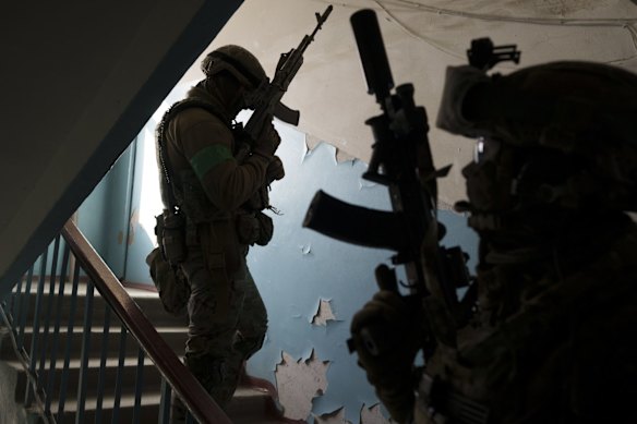 Security Service troops climb the staircase in a building housing Russian collaborators in Kharkiv.