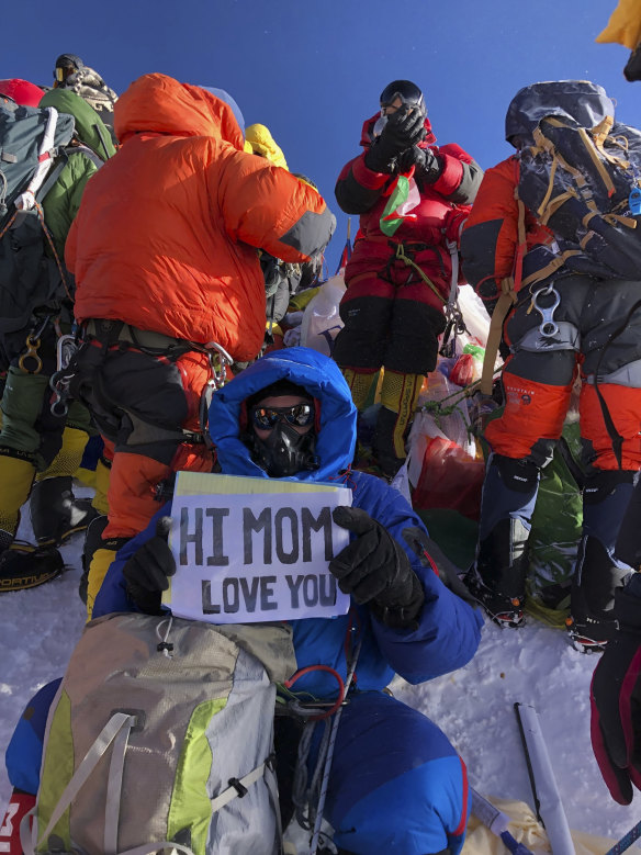 US doctor Ed Dohring holds up a sign for his mother, as climbers jockey for space on the summit of Mount Everest.