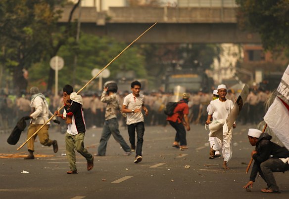 Protestors throw rocks whilst being tear gased by Indonesian police as hundreds gathered for anti US protests infront of the US Embassy in Jakarta, Indonesia.
