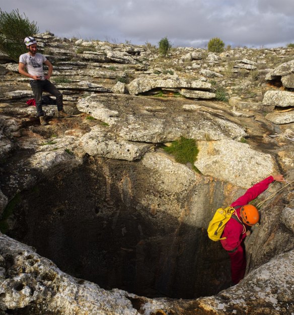 Researchers abseil down the vertical entrance of one of the hundreds of caves on the Nullarbor Plain.