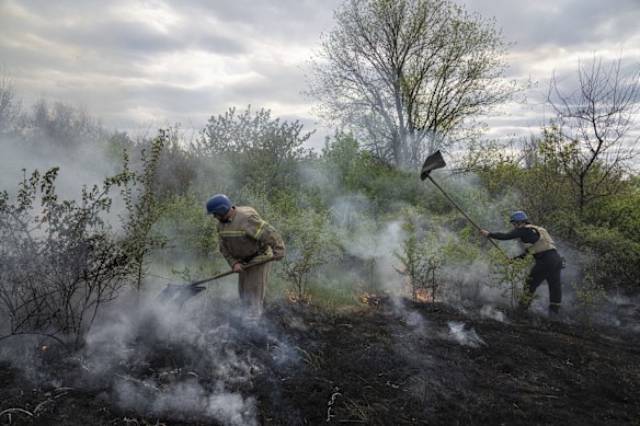 Emergency services personnel extinguish a bushfire after shelling in Mykolaivka, in eastern Ukraine's Donetsk region.