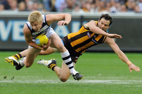 Geelong's George Horlin-Smith gathers the ball in front of Jordan Lewis.