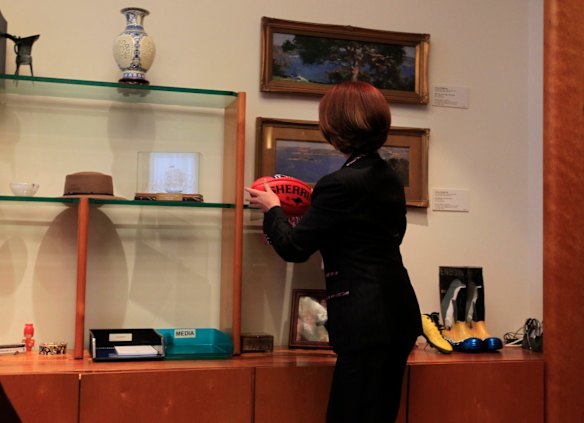 Prime Minister Julia Gillard adjusts her personal items includinga Sherrin footy in the Prime Ministerial suite which she moved into for the first time on Wednesday 30 June 2010. 