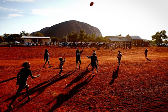 Children playing footy at the back during the closing ceremony at the Mutitjulu community after day 3 of the First Nations National Convention. May 2017