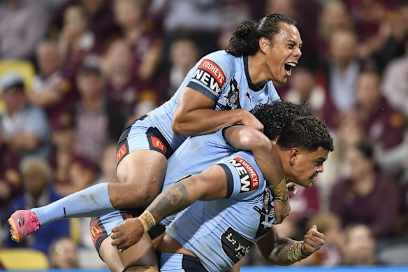 Latrell Mitchell of the Blues celebrates with team mates after scoring a try during game one of the 2021 State of Origin series.