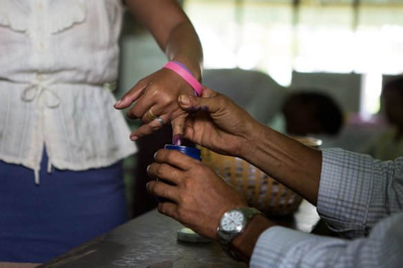 A woman's finger is dipped in ink after casting her ballot in Dala, a village outside of Yangon, Myanmar.