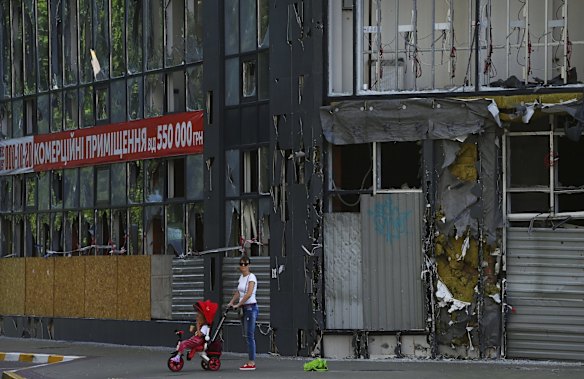 In Bucha, a woman and child stand in front one of the many buildings damaged by shelling and missiles from Russian forces. 